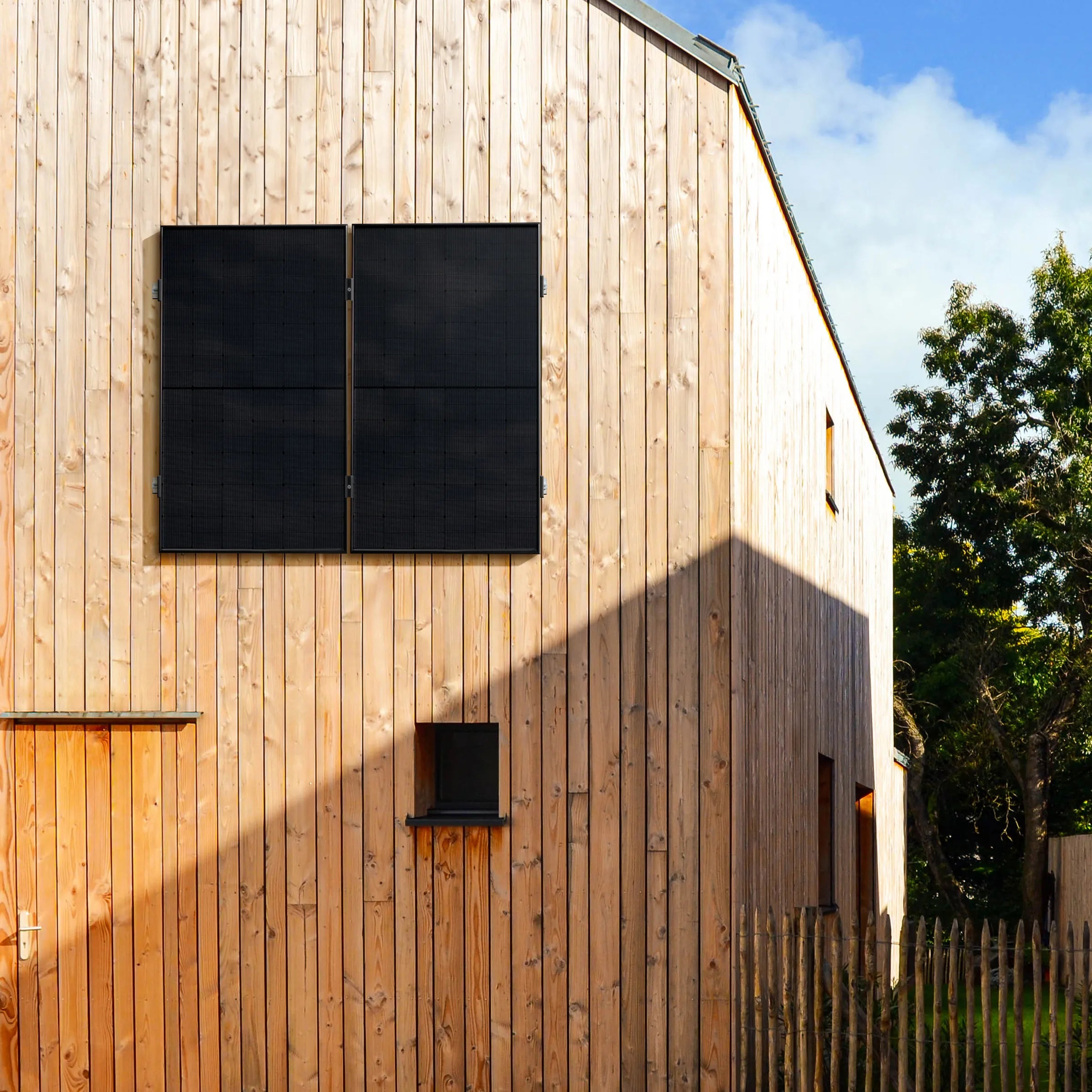 Holzfassade eines modernen Gebäudes mit vertikal montierten Solarmodulen